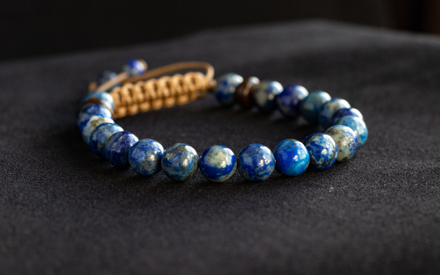 Blue beaded bracelet on a dark fabric background