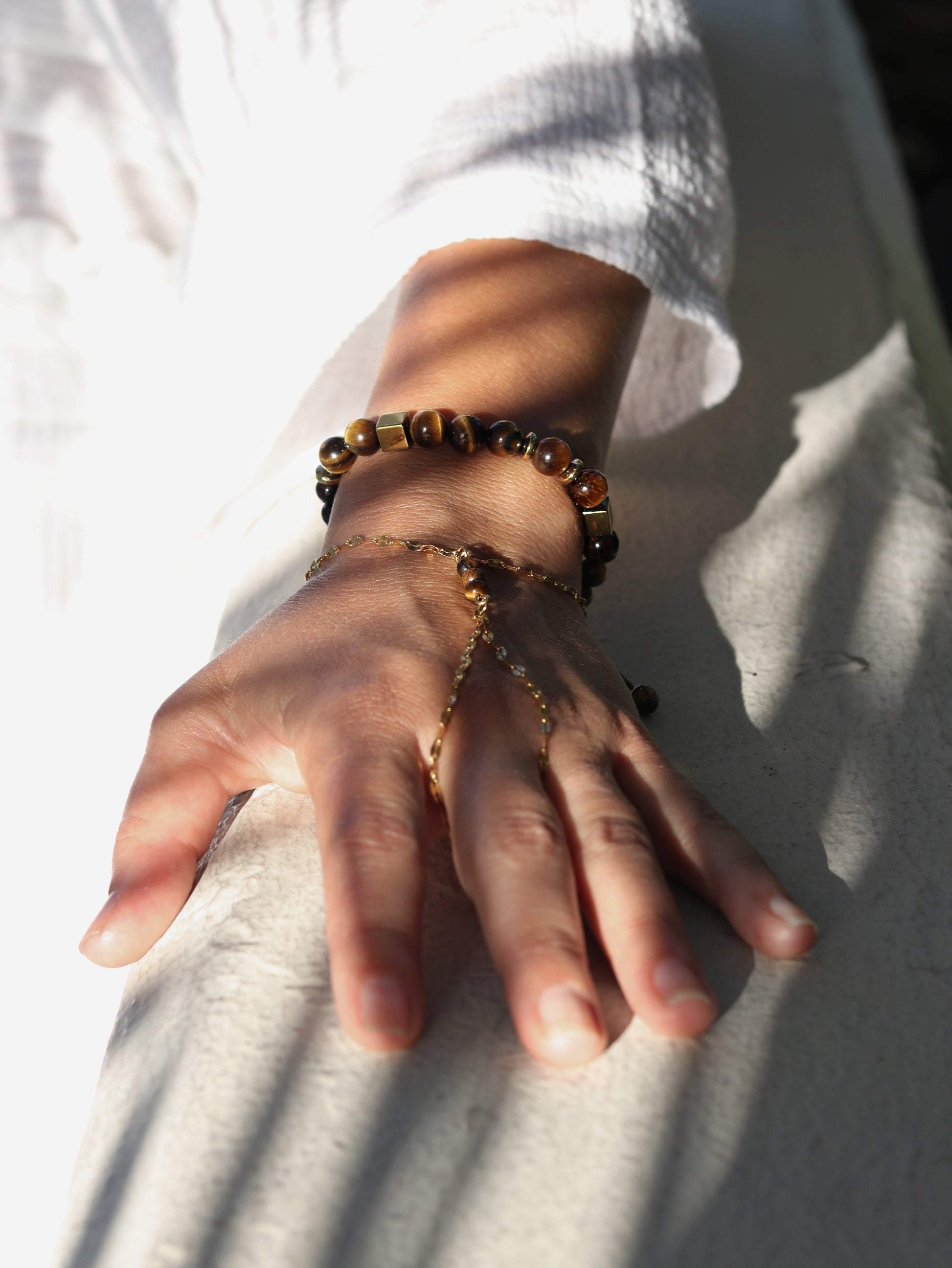 Close up Tiger's Eye hand chain bracelet with adjustable gold chain spiritual confidence jewelry