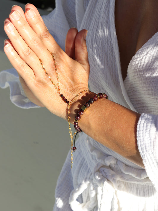Red garnet hand chain bracelet worn on hand showing passionate gemstone beads and gold chain