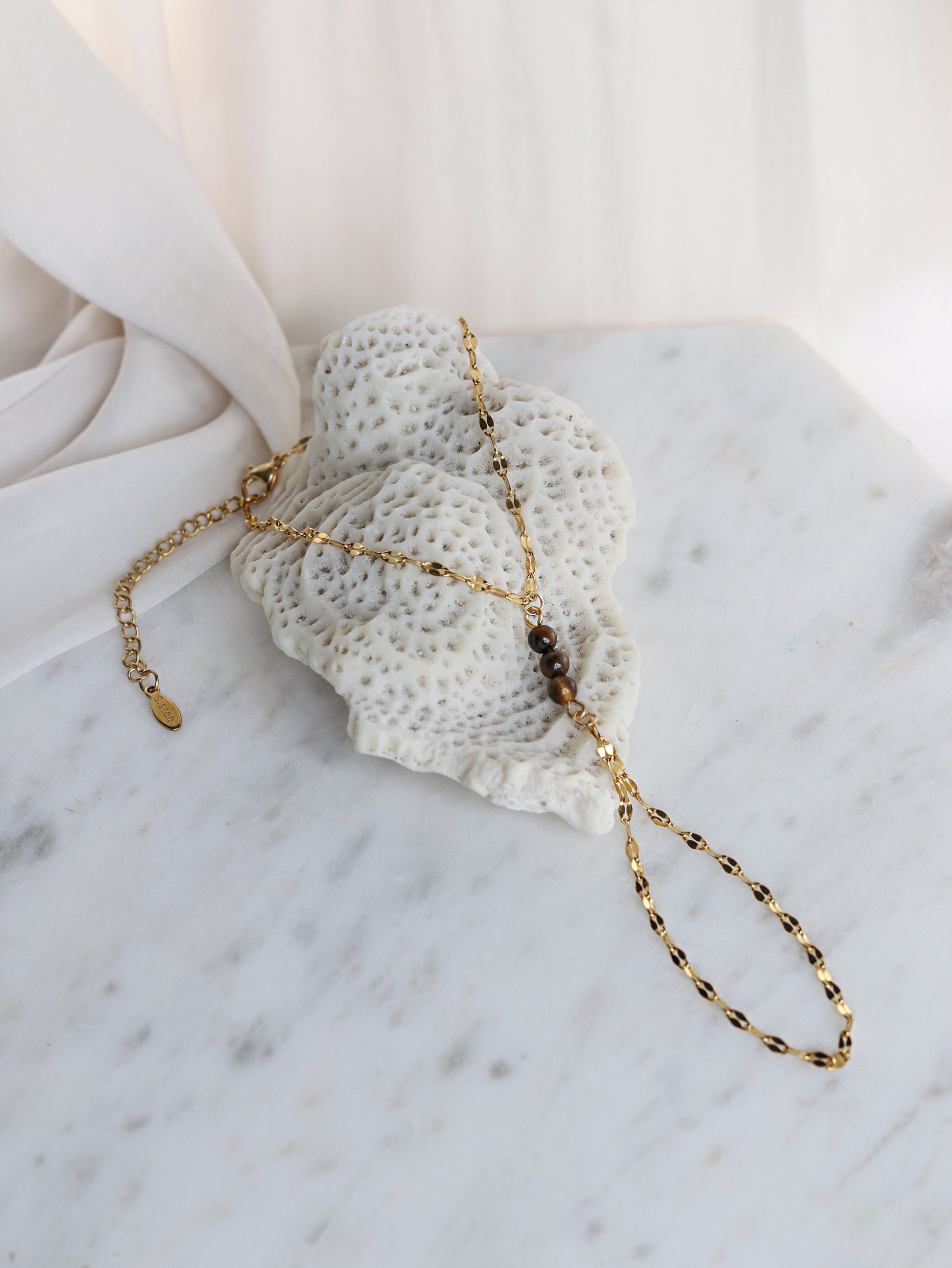 Tiger's Eye hand chain bracelet flat lay styling shot showing adjustable gold chain spiritual gemstone jewelry