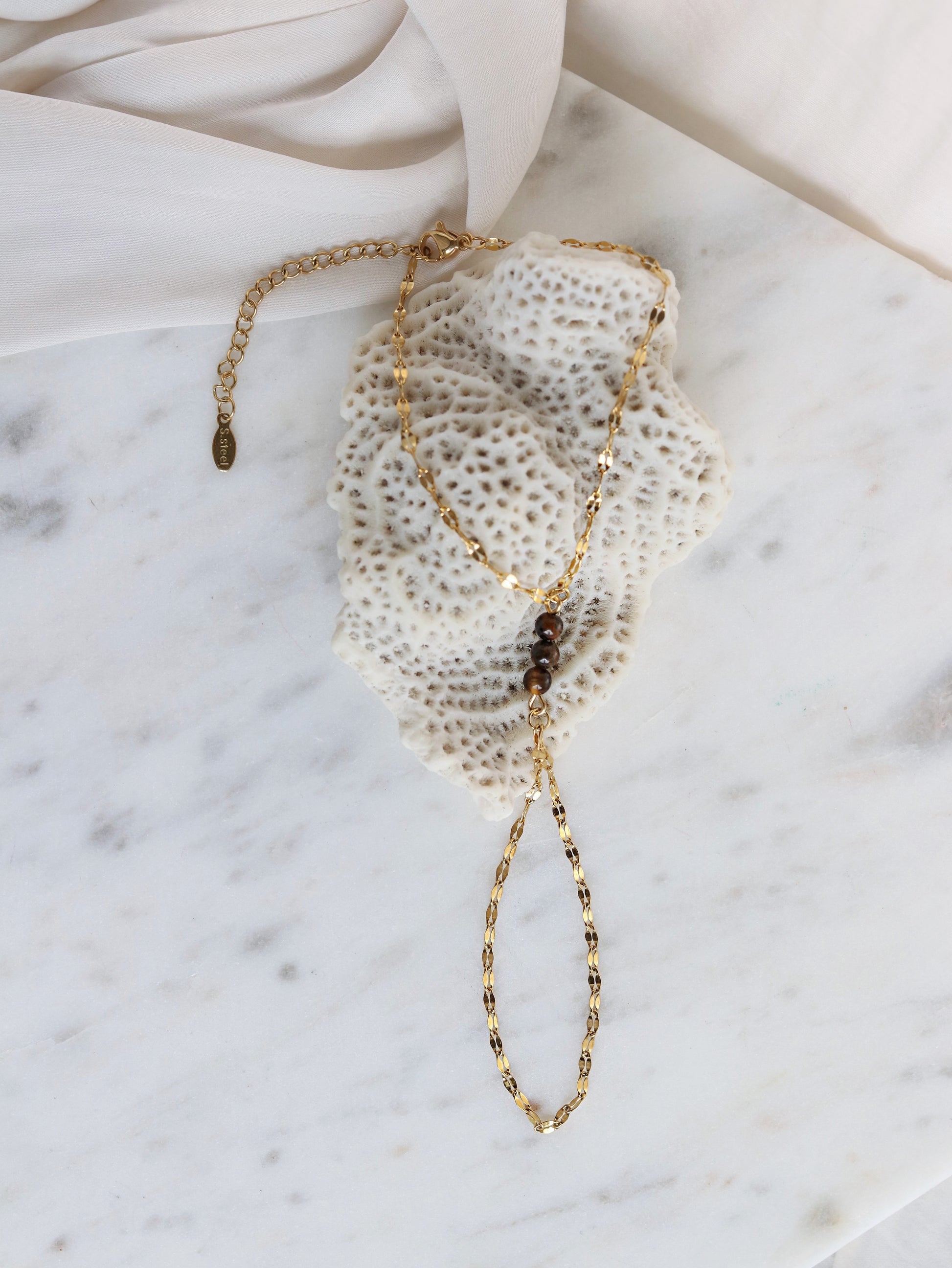 Tiger's Eye hand chain bracelet flat lay styling shot showing adjustable gold chain spiritual gemstone jewelry