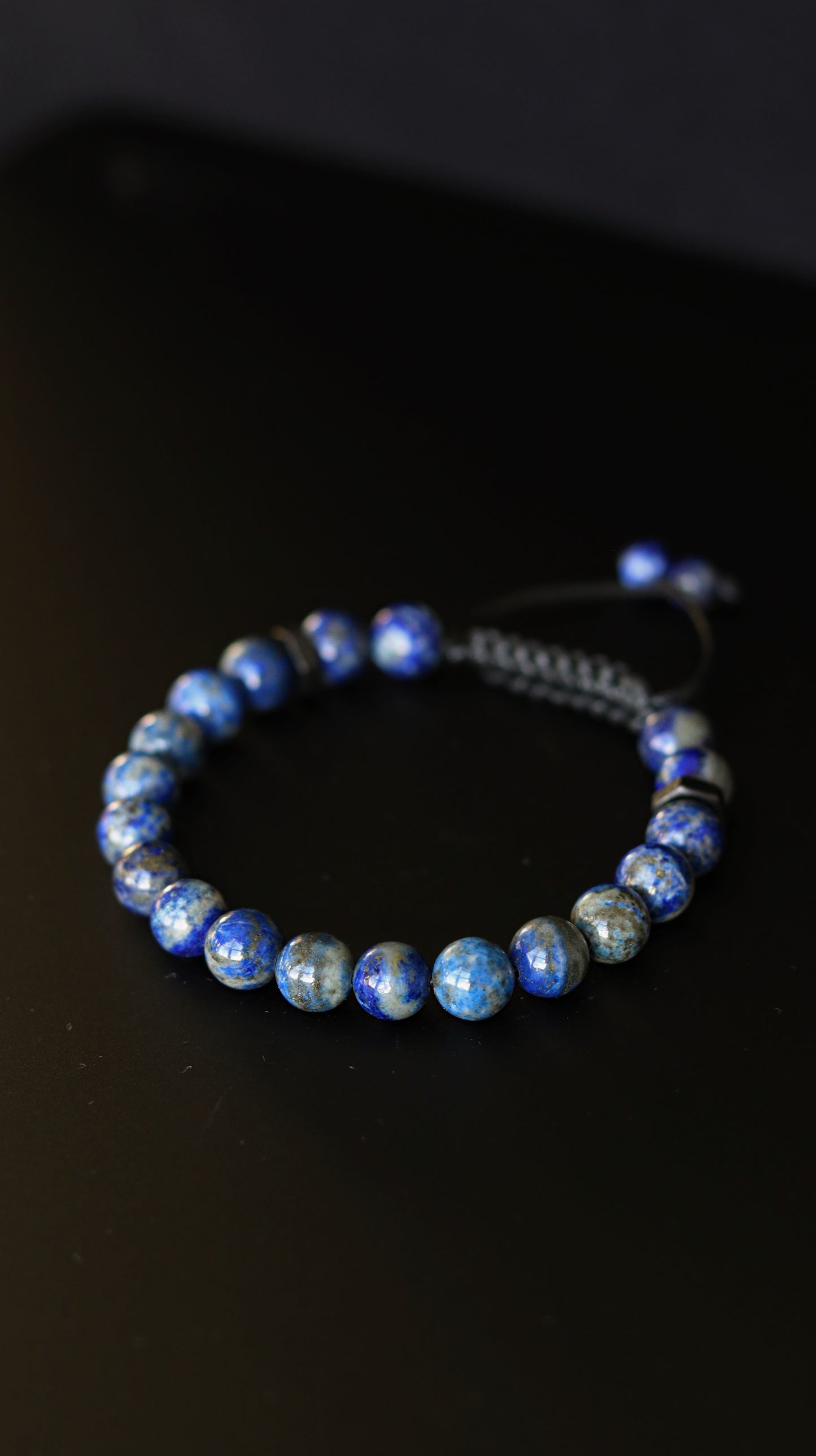 Blue beaded bracelet on a black background