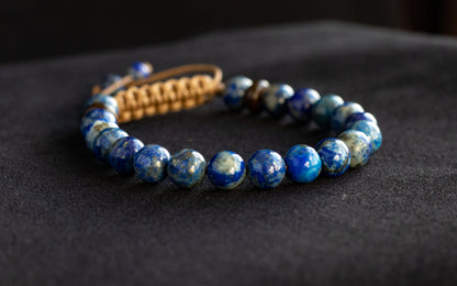 Blue beaded bracelet on a dark fabric background