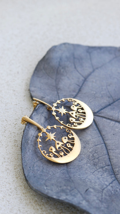 Woman at beach wearing gold mushroom dangle earrings styled with layered gold necklace — nature-inspired 18k gold plated earrings by BURZAN Design
