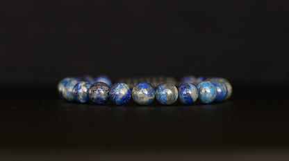 Lapis Lazuli beaded bracelet with blue and silver beads on a black background