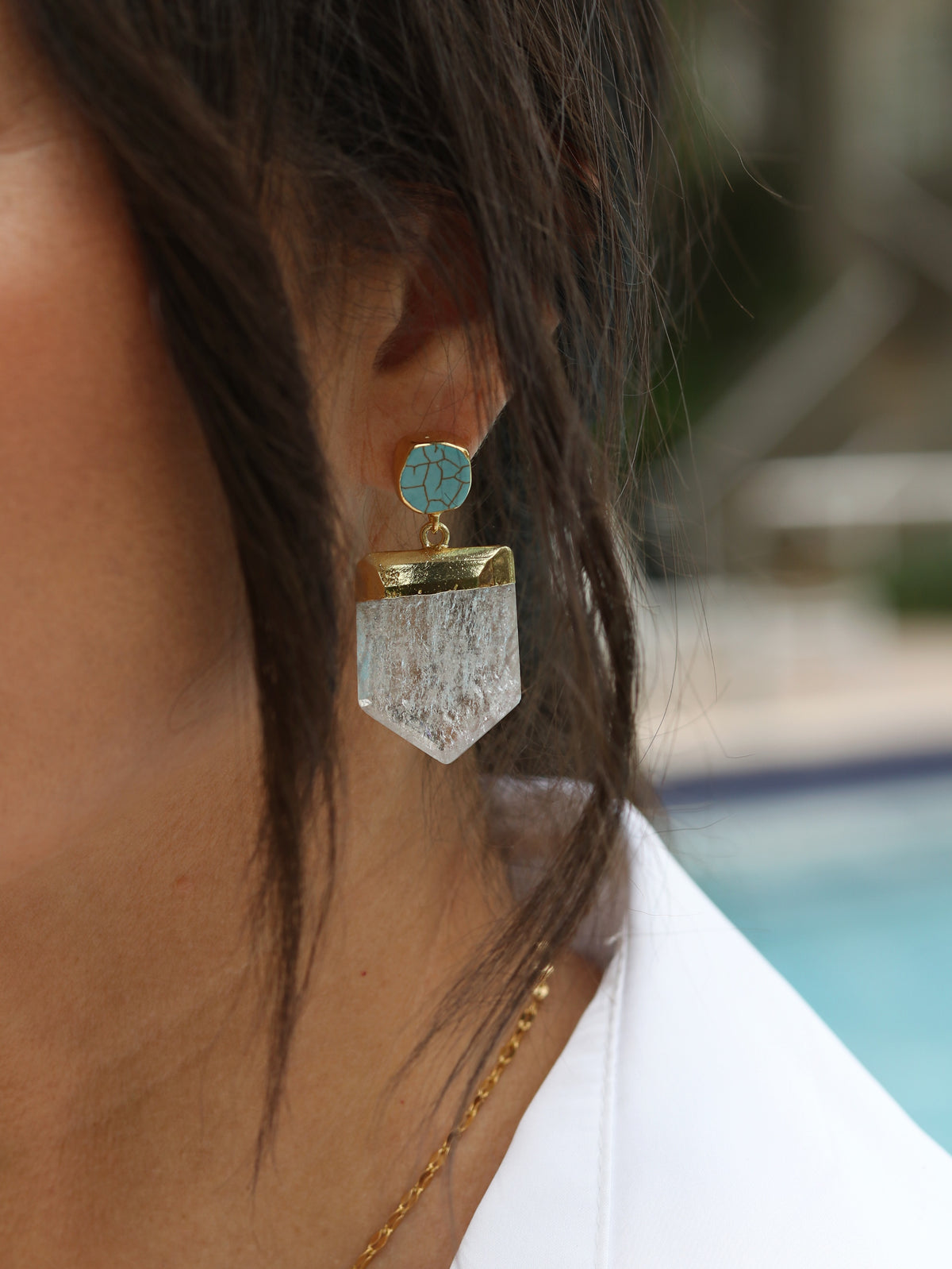 Extreme close-up of turquoise Howlite stud earring with crackle veining in 24k gold bezel and large faceted raw Crystal Quartz shield pendant drop
