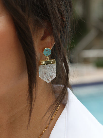 Extreme close-up of turquoise Howlite stud earring with crackle veining in 24k gold bezel and large faceted raw Crystal Quartz shield pendant drop
